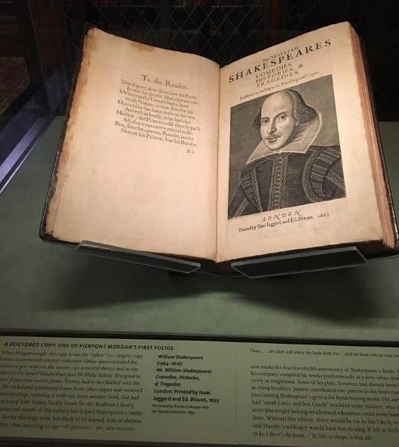 An open folio of William Shakespeare's works features an engraved portrait of the playwright with accompanying text, displayed beneath a historical plaque detailing its significance.