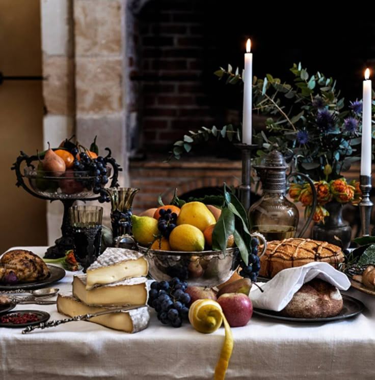 A lavishly arranged table with colorful fruits, artisanal breads, cheeses, and elegant tableware