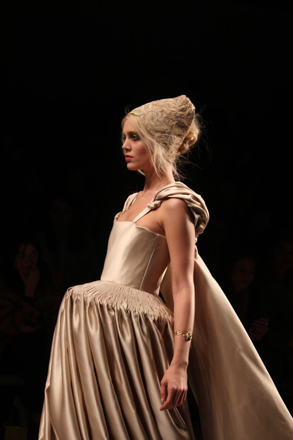 A model showcases a luxurious, flowing gown blending modern and Elizabethan styles