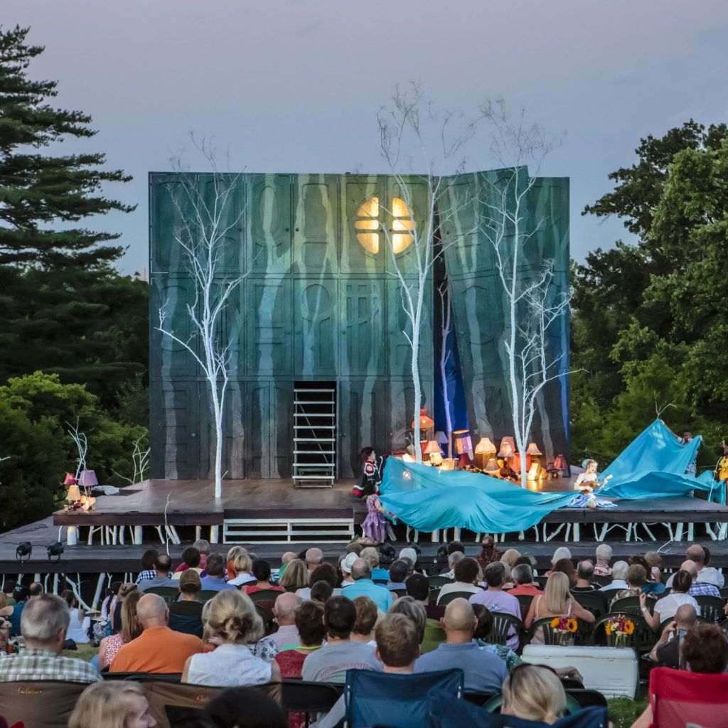 An audience enjoying an open-air Shakespeare performance